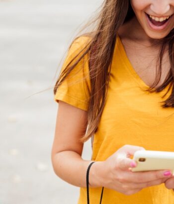 ragazza sorridere con lo smartphone in mano
